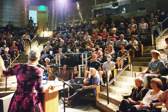 a speaker talks to a full house crowd in tateuchi forum auditorium